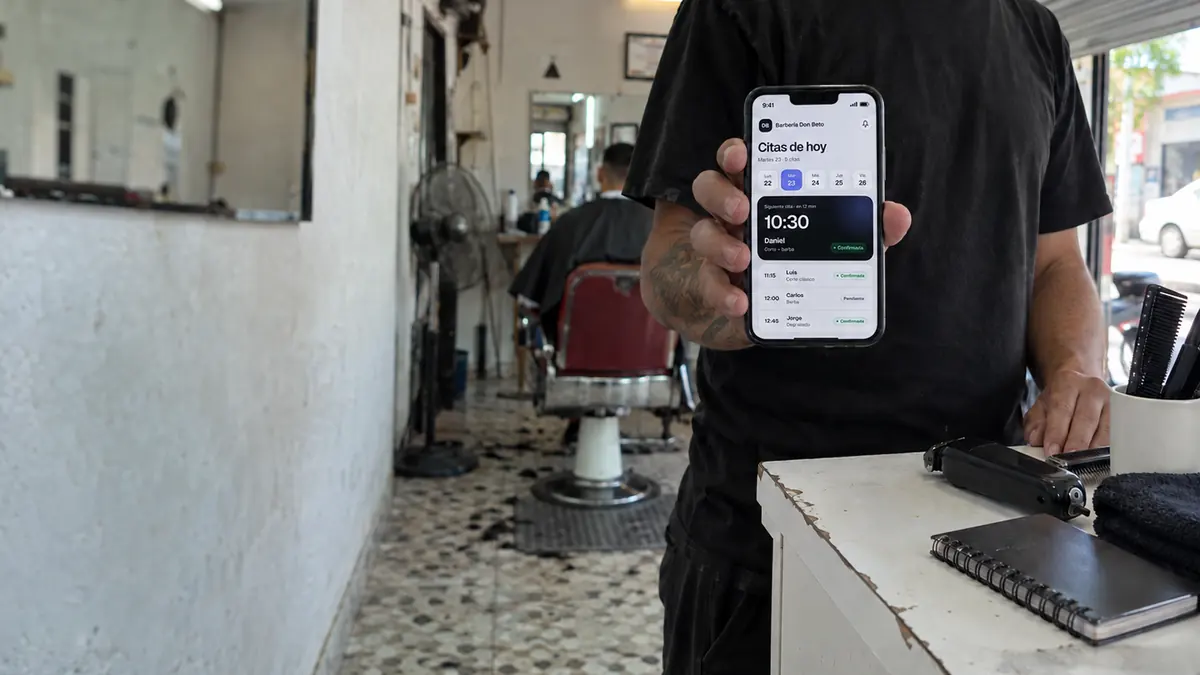 Ejemplo: un barbero revisa en su celular las citas de hoy mientras su cliente espera en el sillón